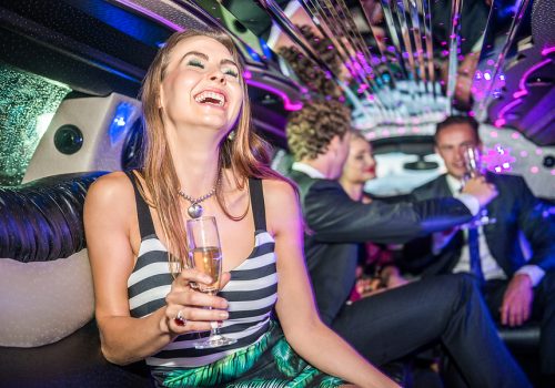 Cheerful Young Woman Holding Champagne Flute In Limo