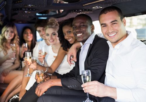 Well dressed people drinking champagne in a limousine on a night out